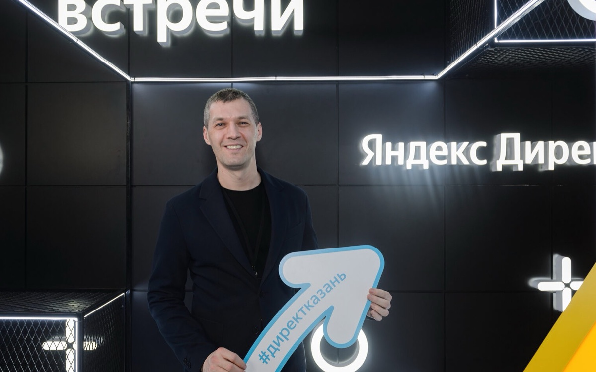 Денис Герасимов на встрече Яндекс Директа, за спиной неоновая вывеска Яндекс Директ